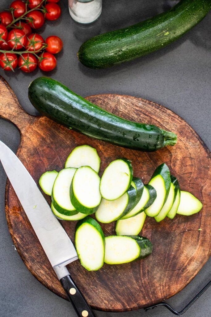 sliced courgettes on wooden board
