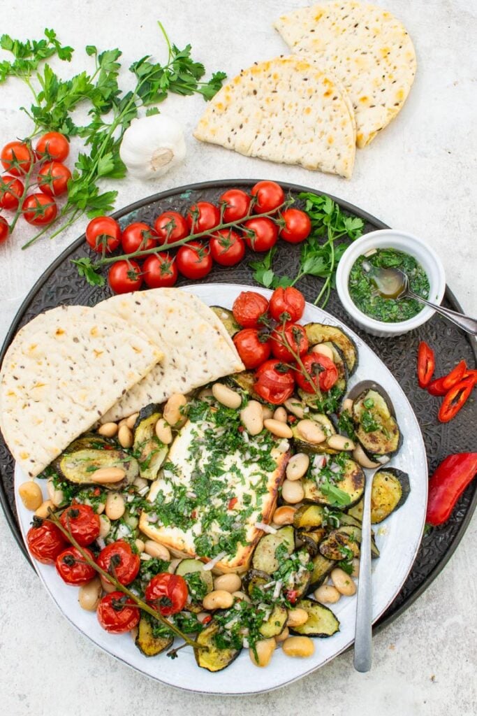 Easy baked feta recipe served on a platter with flatbread