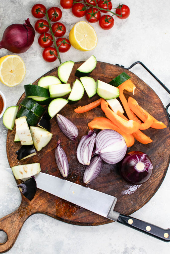 chopped cougette, aubergine, pepper, red onion on chopping board