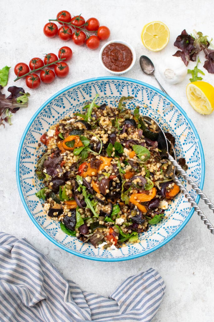 Mediterranean pearl couscous salad in blue salad bowl