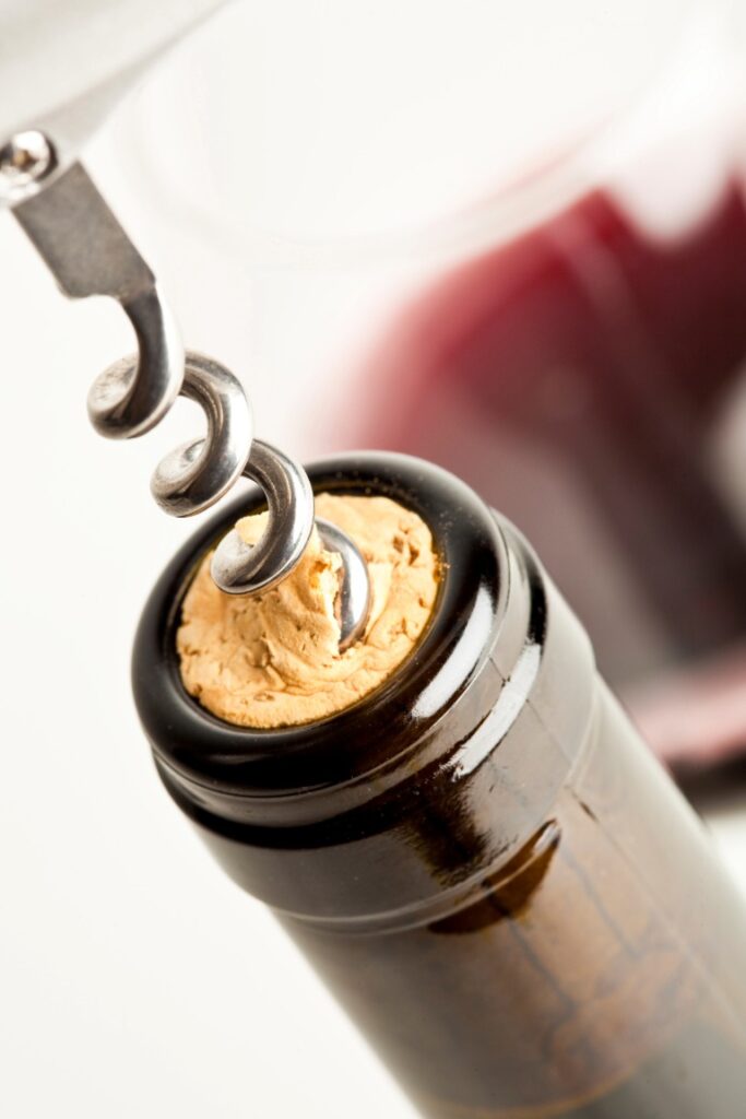 corkscrew with cork and wine bottle