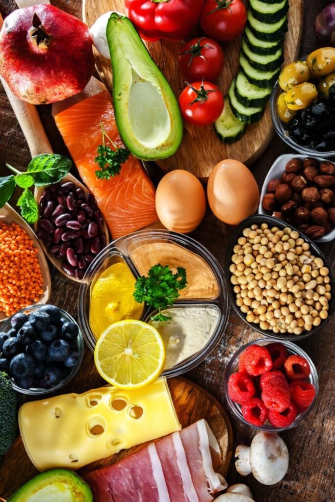 A variety of flexitarian foods including fruits, vegetables, legumes, nuts, eggs, salmon, cheese, and ham