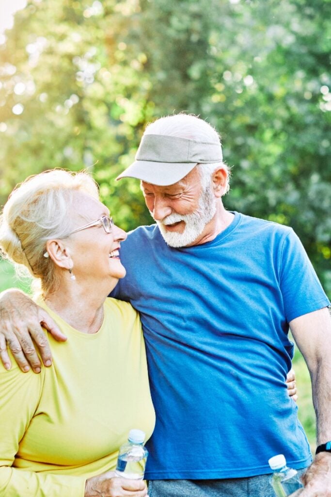 elderly active couple hugging outside