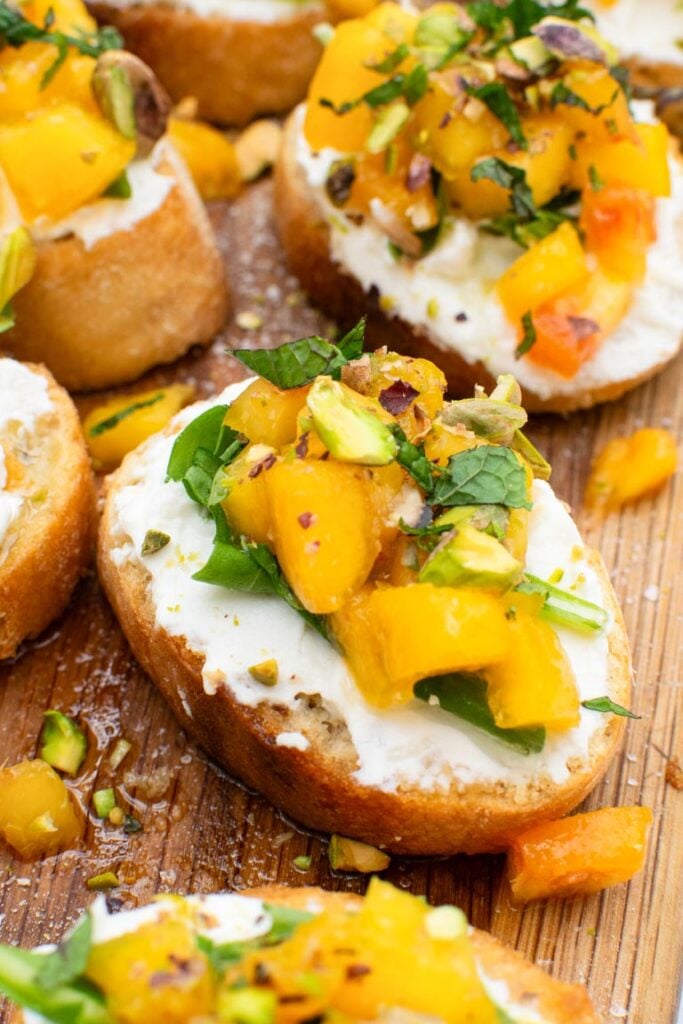 Peach bruschetta with whipped ricotta arranged on a platter for sharing