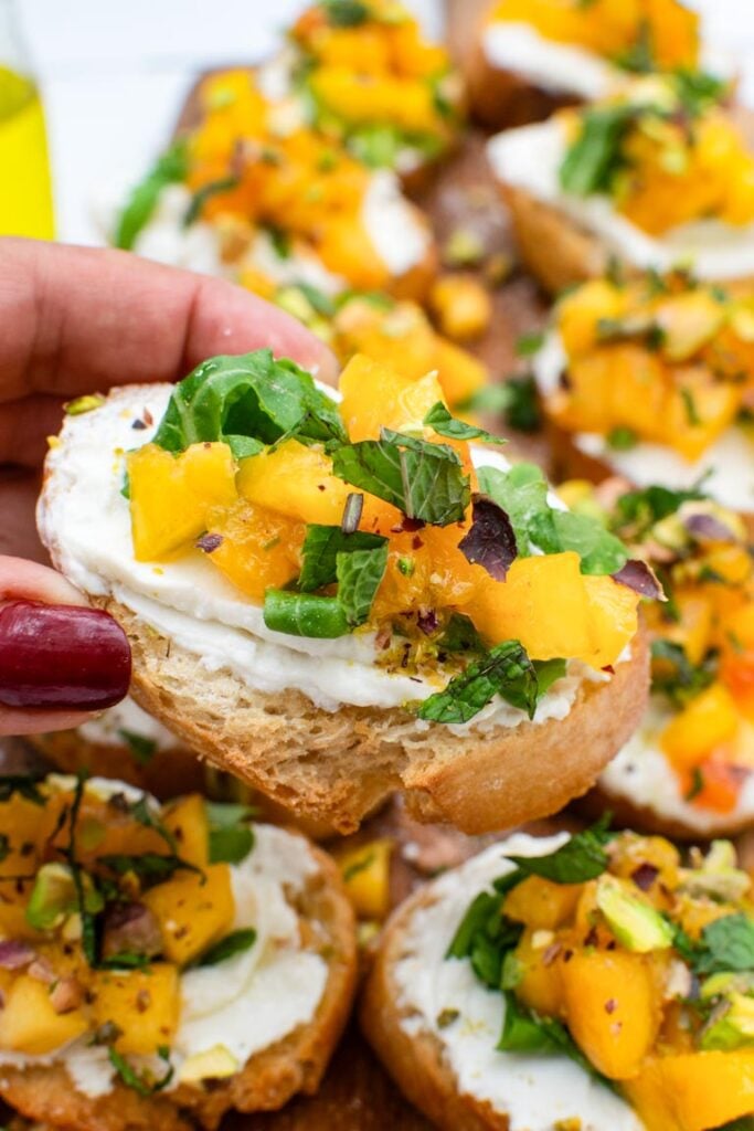 Peach bruschetta with whipped ricotta and pistachios ready to serve