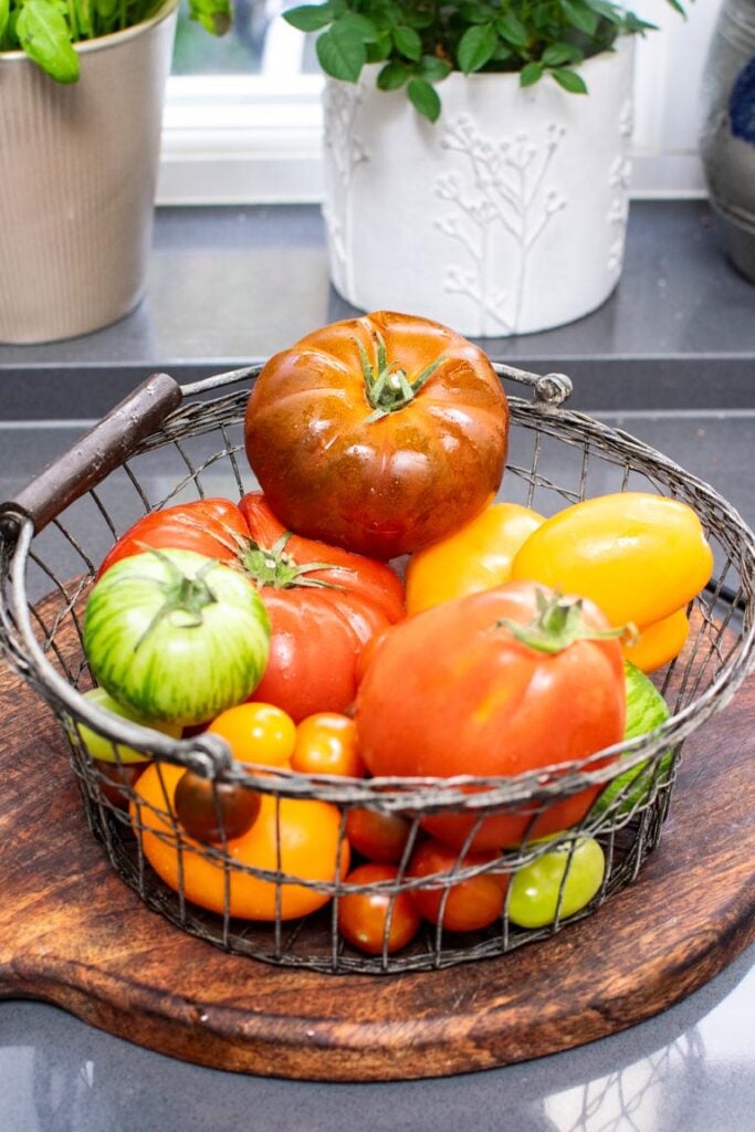 basket of heritage/heirloom tomatoes on wooden board