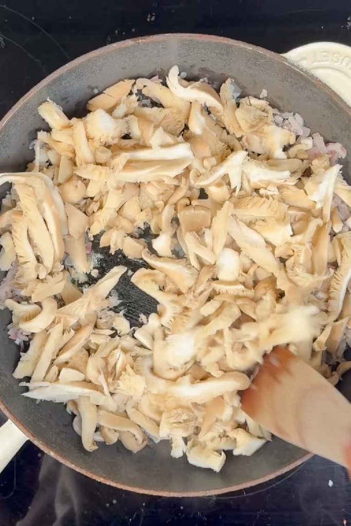 Oyster mushrooms frying in a pan for baked eggs with mushrooms