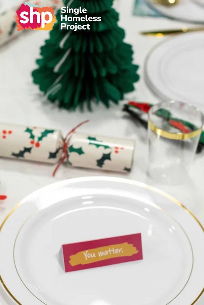 Christmas place setting with a 'You matter' name card, cracker and paper Christmas tree for a Single Homeless Project dinner