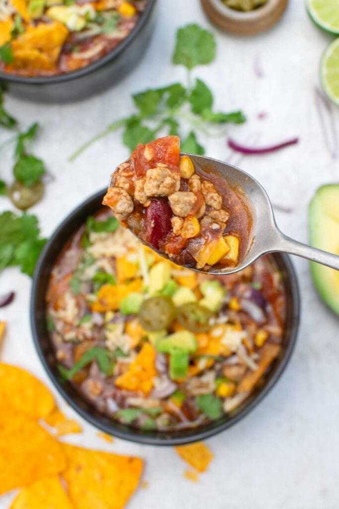 Spoonful of taco soup lifted from the bowl, showing Quorn mince, kidney beans and sweetcorn