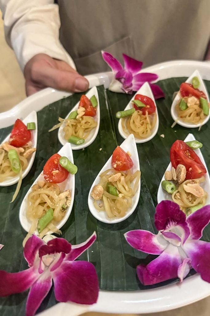 Vegan green papaya salad canapés served in white spoons, topped with cherry tomato, long beans and peanuts, at the Tastes of Love and Light book launch