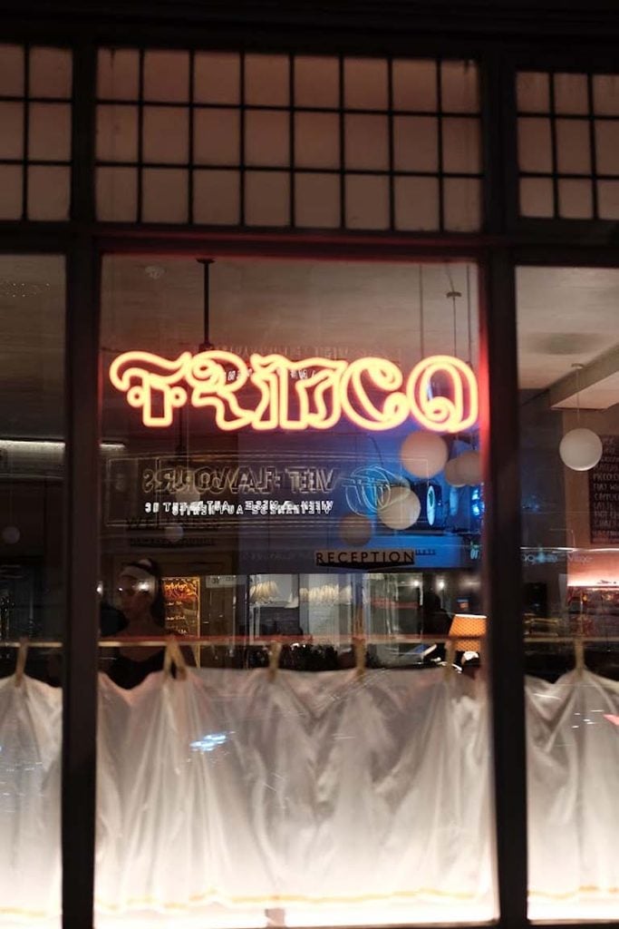 Trinco neon sign in the window of Oru East Dulwich at night